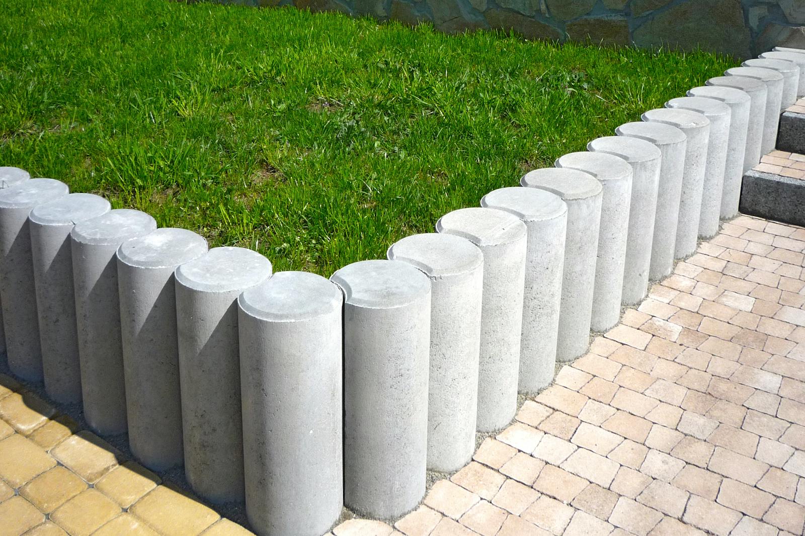 Sharp concrete-cut edge between a small Bermuda lawn and a granite bed.