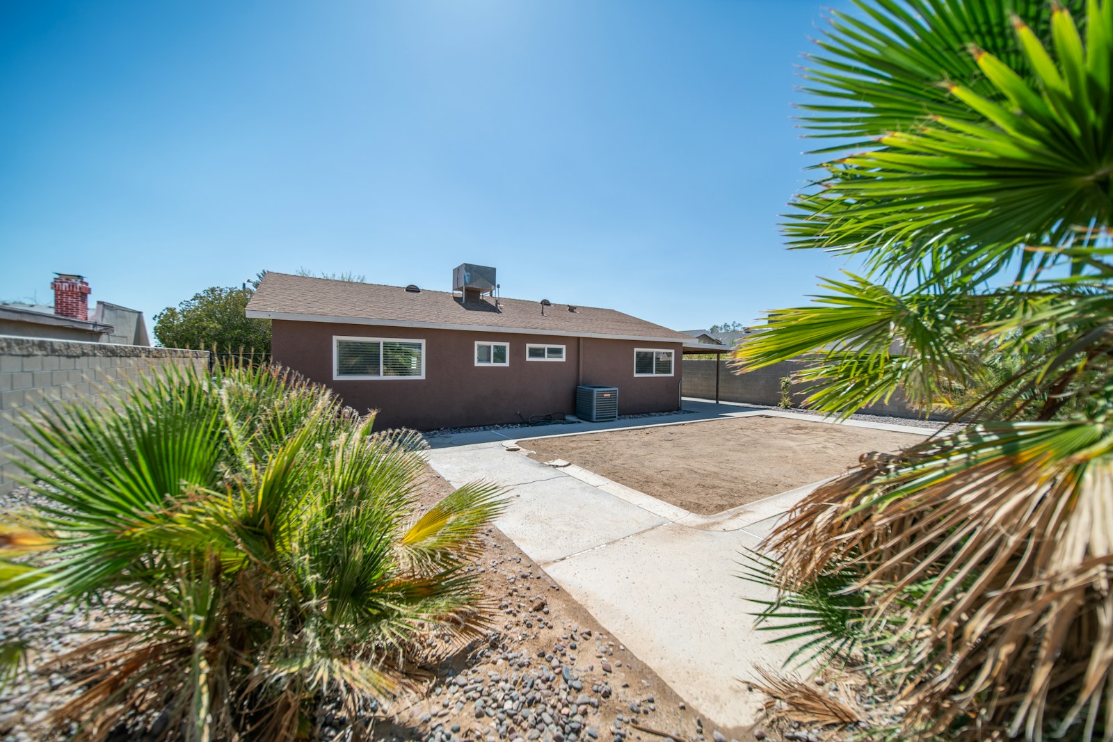 Two-story Anthem-style house with mature date palm and freshly raked front yard.